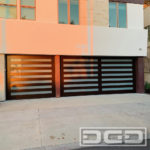 Espresso heart-grain finished garage doors in a horizontal open slat design with white-laminate glass panes between the spaces. These are composite full-view garage doors with a faux wood grain appearance.