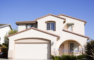 Stucco home exterior against a clear blue sky near sunset. Typical Southern California architectural style.